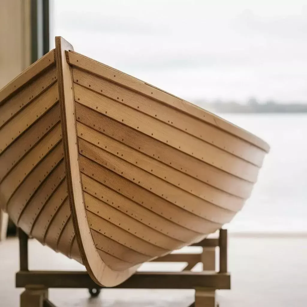 Coastal boatyard at sunset with wooden hull mid-construction in Cochin Wood BWP marine plywood